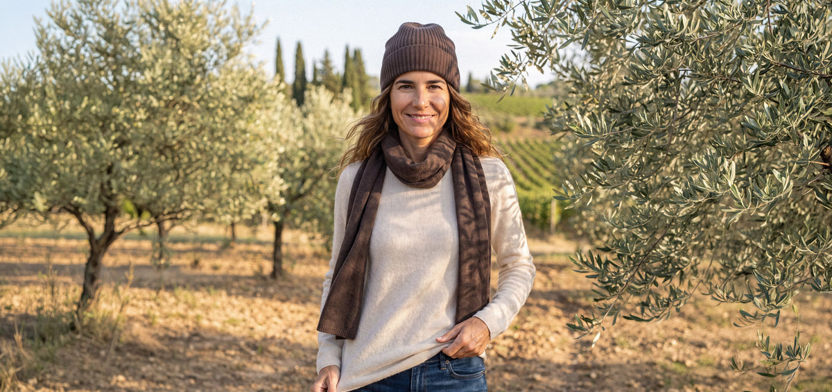 Donna con berretto e sciarpa in cashmere tra gli ulivi