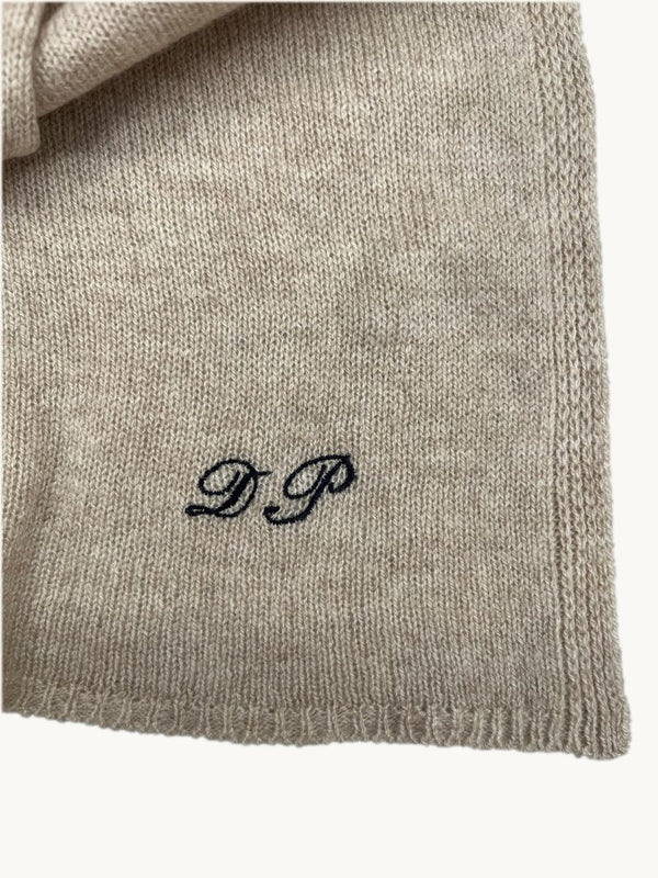 Iniziali DP ricamate in blu navy su una sciarpa in cashmere beige